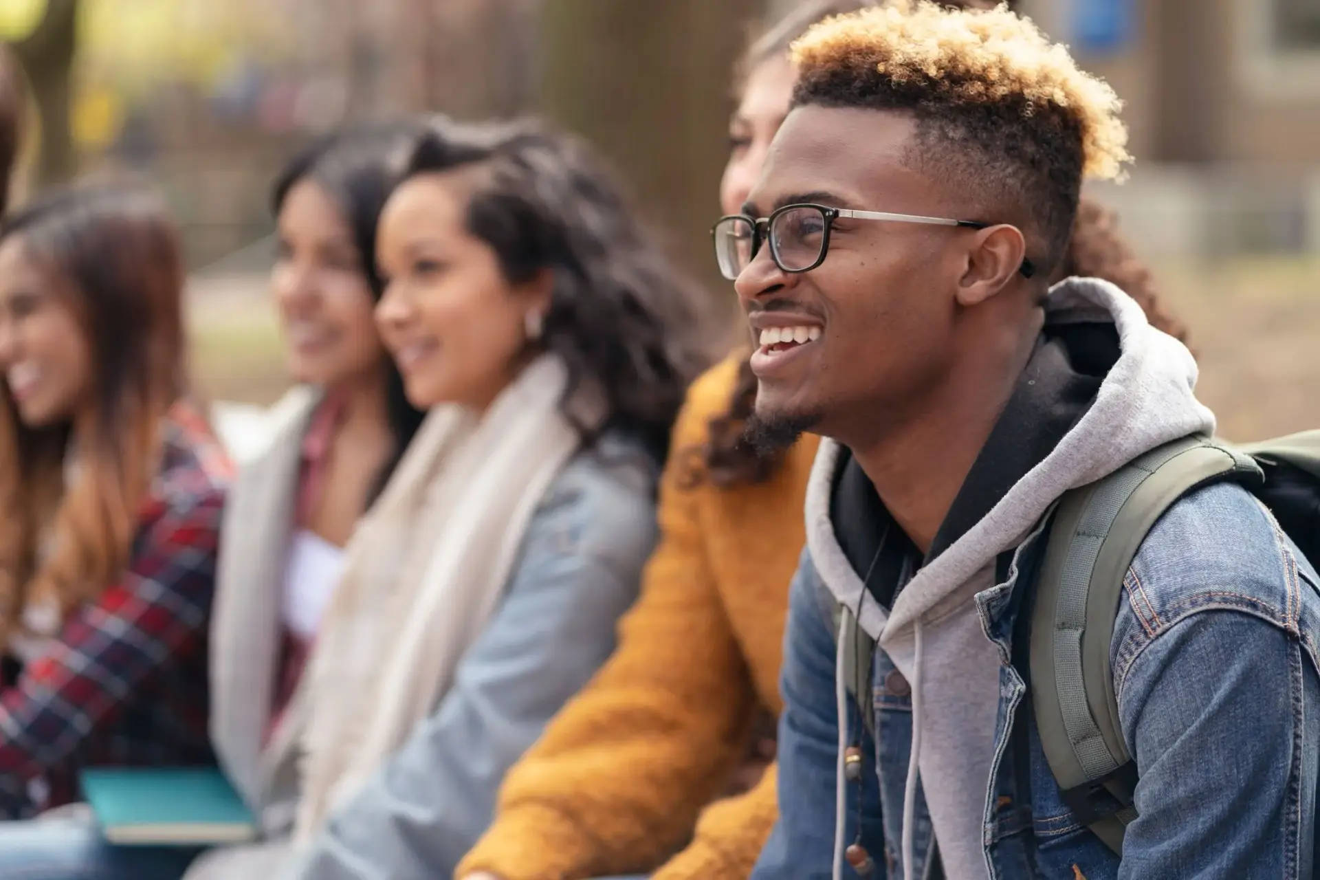Smiling teens sitting together outdoors
